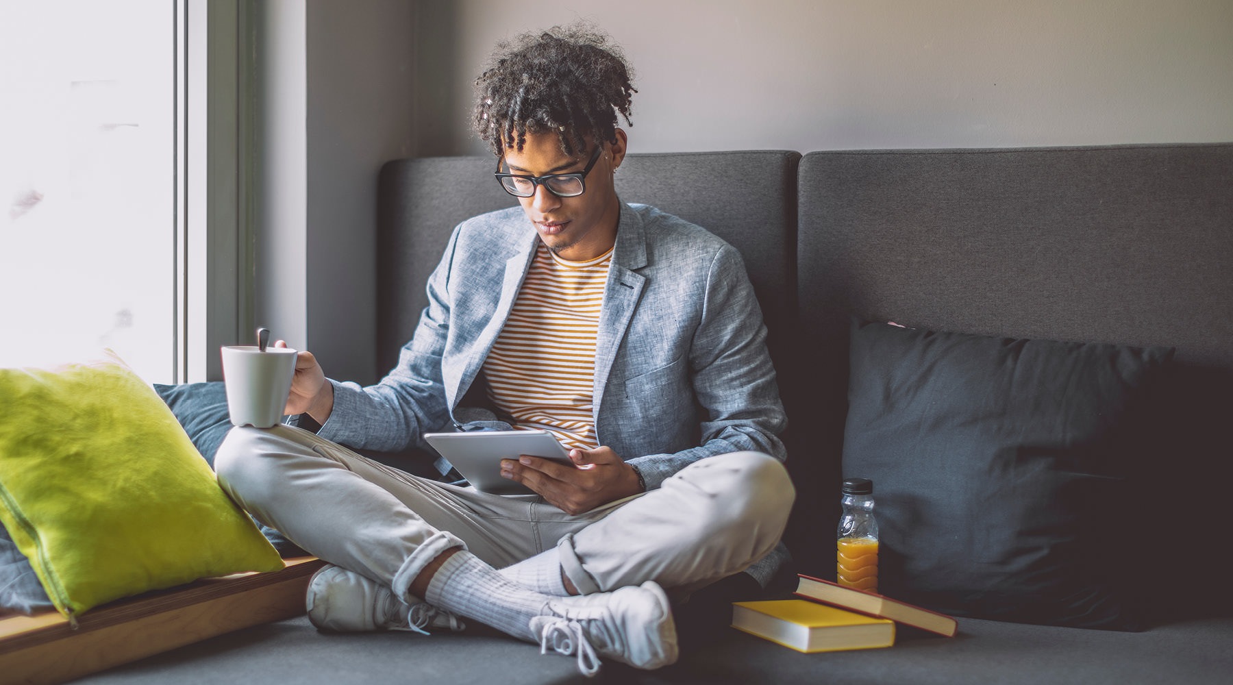 man on a couch looks at his tablet
